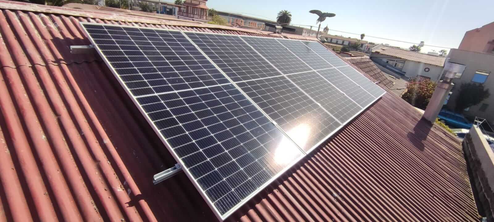 Paneles solares sobre techo de calamina roja en el Hostal Balmaceda, como parte de su compromiso con la energía sustentable